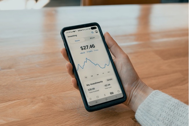 Person holding phone showing stock market chart
